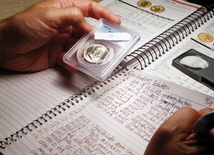 someone holding a coin with a notebook