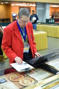 man with laptop at an exhibit at a show