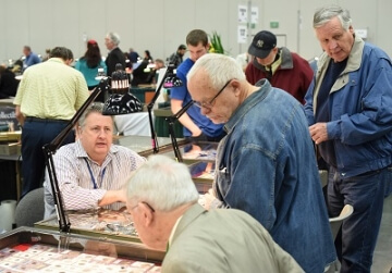 people at a booth at a coin show