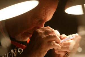 man examining coin with loupe