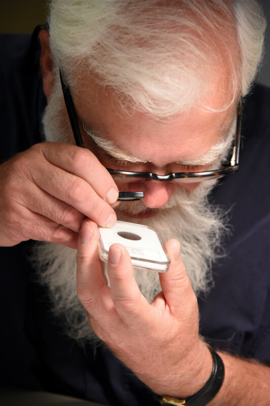 man studying coin loupe clubs summer seminar ss