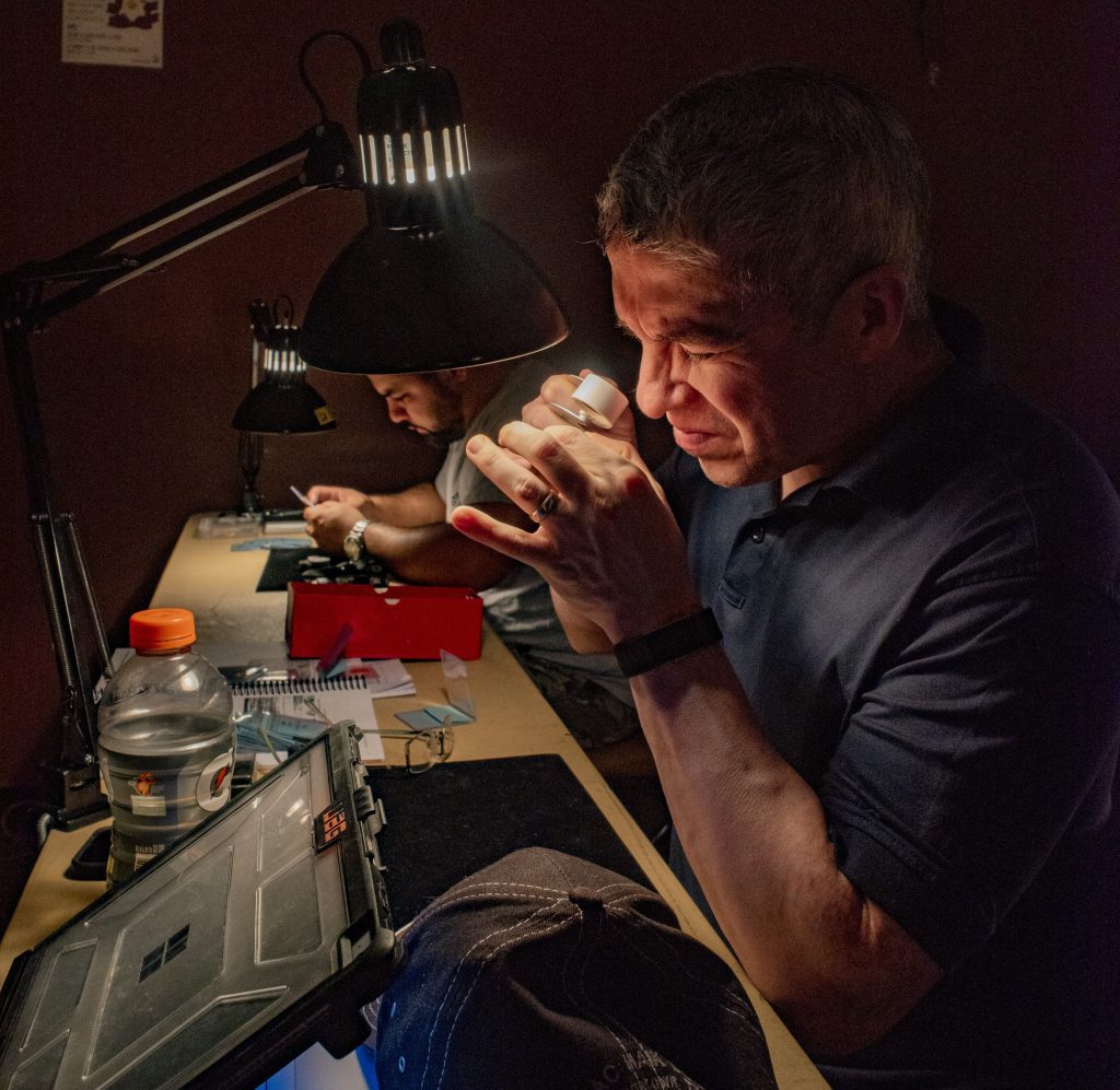 Man Studying Coin at Numismatic Seminar